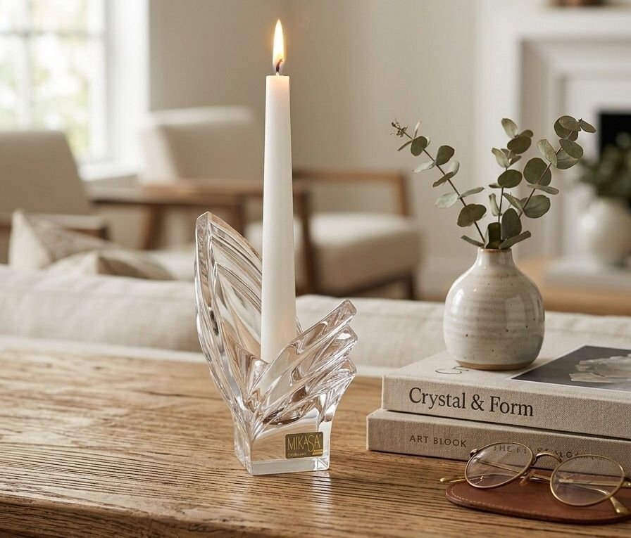 Clear Mikasa Germany crystal taper candle holder with lit white taper, Art Deco geometric wings and foil label at base.
