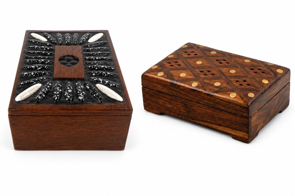 Front view of two handcrafted wooden boxes: left with black-and-white stone inlay; right with parquet top with brass dots.