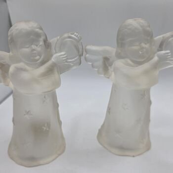 Front view of the pair of frosted glass angel tealight holders showing full bodies, bases and molded candle cups on top.