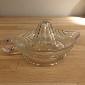 Front view of Anchor Hocking clear glass lemon reamer showing fluted juicing cone, ribbed interior and pour spout.