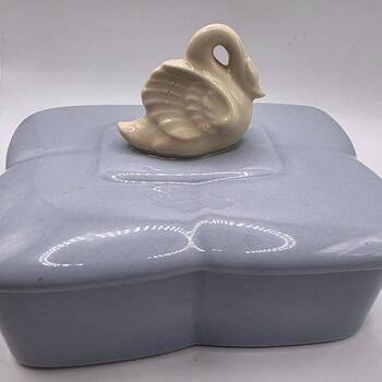 Front-angle view of the glossy gray rectangular trinket box with the cream-colored swan lid centered on top, showing the box profile and finish.