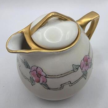 Three-quarter view of Epiag Royal creamer showing body with pink floral band and gold-gilt rim, spout and handle.