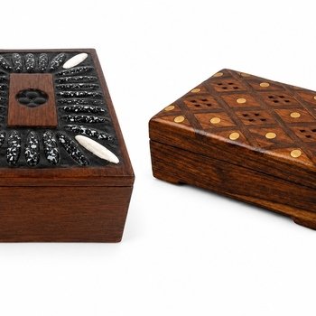 Close angled view showing parquet-top box with brass dot inlay and partial view of the adjacent black-and-white stone inlay box.